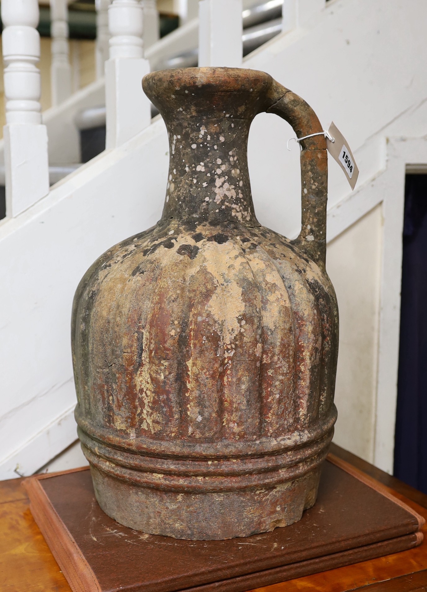 A large Mediterranean terracotta ewer, lacking base, 47cm